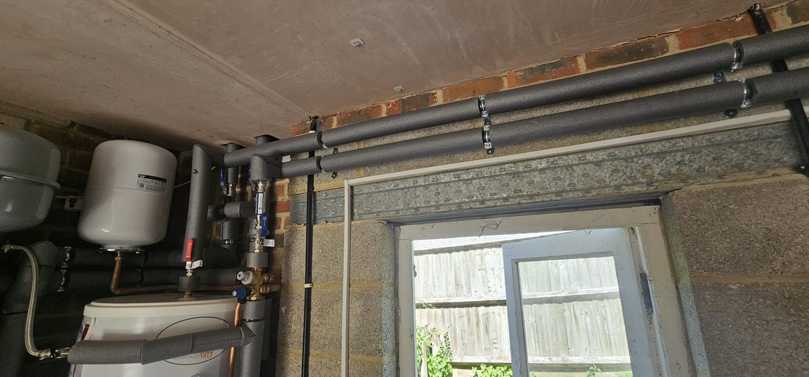 Insulated flow and return pipework running at ceiling level with isolation valves
